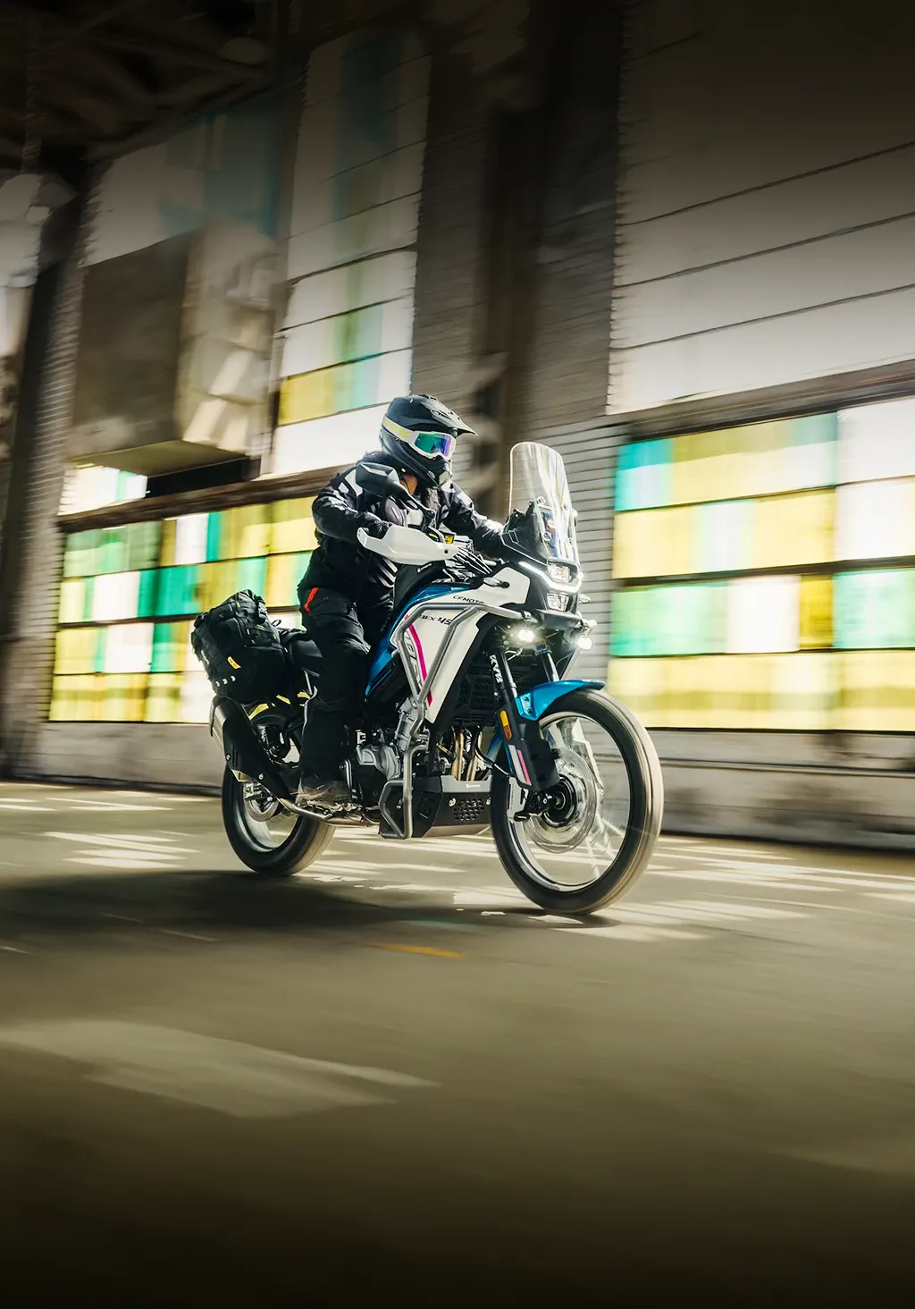 Piloto em movimento com a moto de aventura CFMOTO IBEX em um galpão industrial